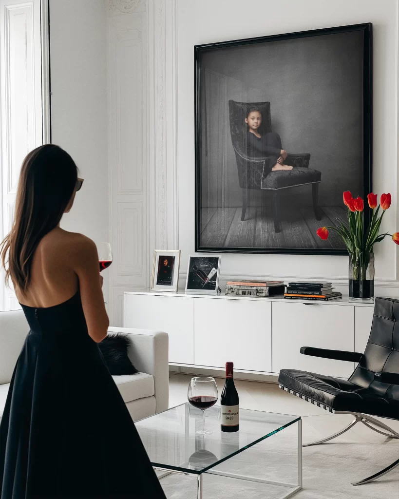 Framed fine art portrait of a young girl sitting on a chair, displayed as wall art in a sophisticated setting, showcasing timeless photography and elegant presentation